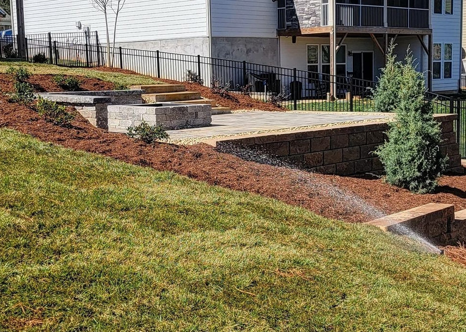 Patio built in a Charlotte backyard that has a slope using a retaining wall